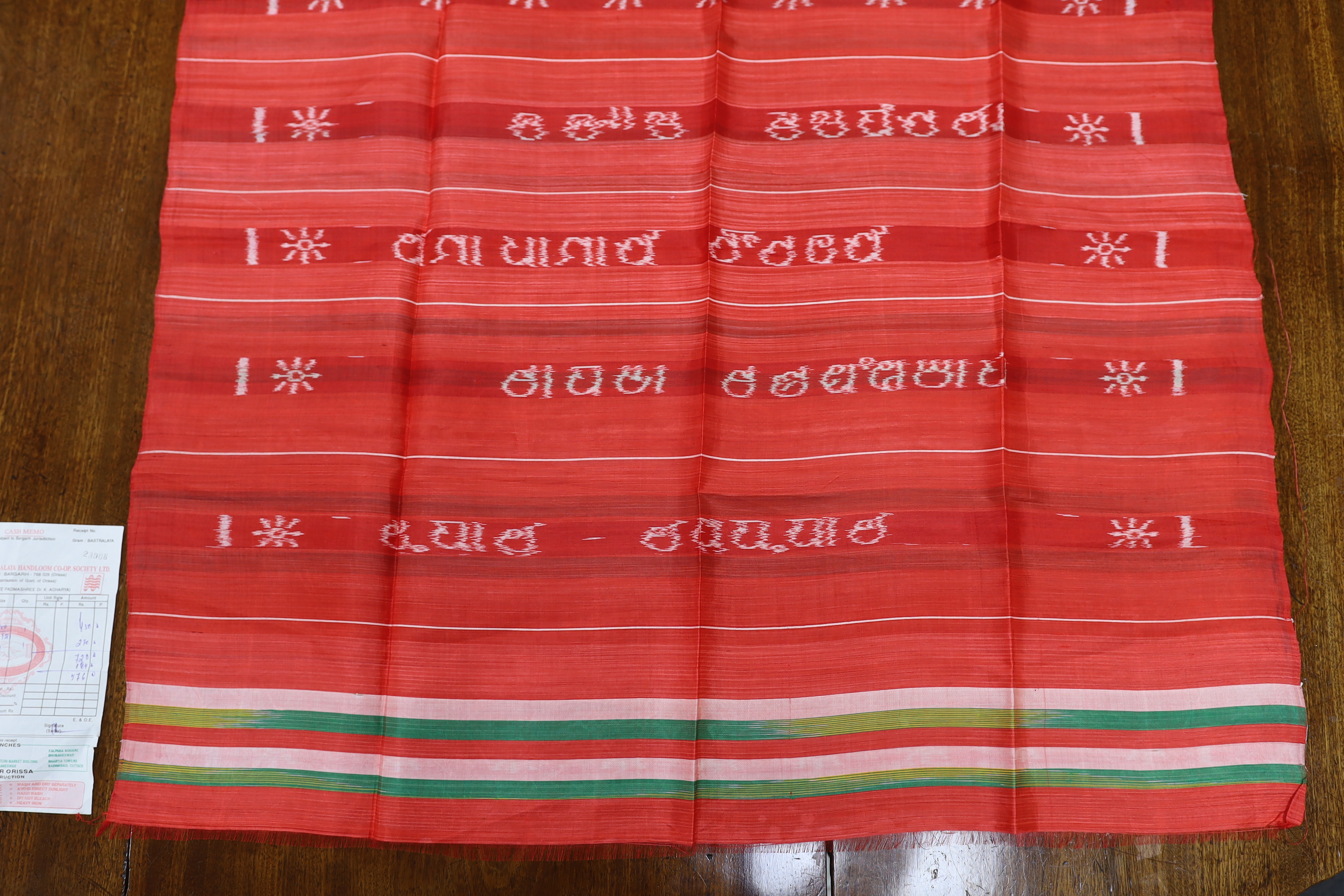 An Indian silk woven cloth, possibly a temple cloth, from Orissa, printed on the warp, with original receipt and paper bag